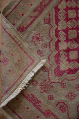 Vintage Khotan runner with distressed pile, showing visible foundation and raspberry red plant motifs.