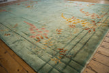 Contoured details of a vintage Art Deco carpet, seafoam green field, blush florals, and bamboo stalks.