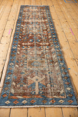 Hand-knotted Heriz runner detail showing blue border, chestnut geometric patterns, and foundation wear.
