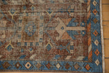 Vintage Heriz runner corner featuring sky blue geometric border and visibly worn pile.