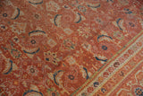 Close-up of vintage Mahal rug's worn Herati pattern and border in orange, blue, and beige.