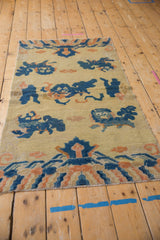 Close-up of antique Ningxia rug's pictorial blue Fu dog and mountain range design.