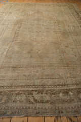Distressed vintage Oushak rug showing faded beige patterns and mostly even wear.