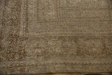 Distressed Oushak carpet corner detail, beige and brown worn pile, secured selvage.