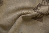 Distressed pile texture of a vintage Oushak rug, highlighting time-softened ivory and brown geometric shapes.