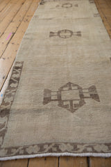 Vintage distressed Oushak rug runner, geometric medallion with even wear and visible foundation.