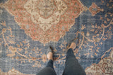 Distressed Sparta carpet with mostly even wear, denim blue, apricot, ivory scrolling vinery.