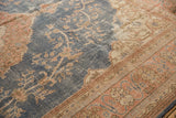 Distressed texture and scrolling vinery in apricot against denim blue field of vintage Sparta rug.