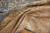 Folded distressed Sparta rug revealing foundation, worn side cord, denim blue, apricot tones.
