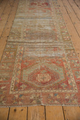 Detail of the distressed Oushak runner showing worn foundation, geometric patterns, and soft madder red.