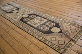 Distressed Oushak runner with geometric hook and latch motifs and wear to knot heads.