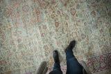Distressed vintage Mahal carpet with foundation visible, pale seafoam green, and faded floral design.