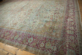 Distressed Persian Mahal rug corner, featuring raspberry scrolling border and seafoam green floral field.