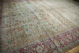 Distressed vintage Mahal carpet texture, revealing worn pale seafoam green and fuchsia floral vinery.