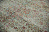 Distressed vintage Mahal carpet's worn pile, with faded vinery in seafoam green, raspberry.