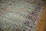 Distressed vintage Mahal carpet, highlighting raspberry fuchsia scrolling border and worn seafoam floral field.