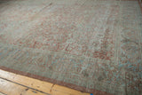Distressed Mahal rug corner, faded Herati vinery in dusty mauve and soft blue.
