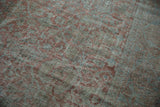 Distressed vintage Mahal carpet detail, showing faded Herati vinery in muted mauve and blue.