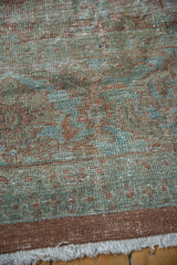 Worn pile of distressed Mahal carpet, intricate vinery pattern, fringe, and soft colors.