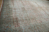 Distressed Mahal rug texture, faded Herati motif in dusty mauve and slate blue.