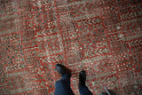 Distressed Vintage Khoy carpet showing cinnabar red field with worn tree-of-life garden motifs.