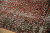 Detail of distressed Khoy rug with cinnabar red field, faded garden motifs, and visible foundation.