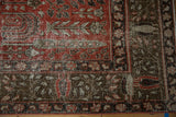 Distressed Khoy rug corner, faded red and brown botanical patterns, foundation showing.