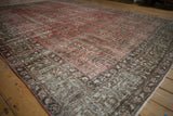 Side view of distressed Khoy rug showing faded cinnabar red field, chocolate border, and pink selvage.
