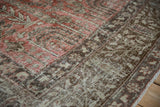 Textured weave of the distressed Khoy carpet, showcasing faded cinnabar red and chocolate motifs.