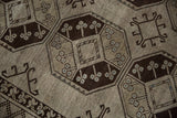 Close-up of distressed Ersari rug with dark chocolate brown gul, beige pile, and blue accents.