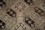 Distressed Ersari runner detail: worn pile revealing geometric hook motifs in brown and beige.