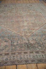 Distressed pile texture of a vintage Kamseh rug with muted blue and mauve geometric patterns.
