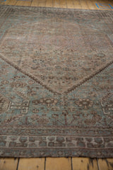 Vintage distressed Kamseh carpet, faded dusty blue and brown geometric patterns, worn pile.