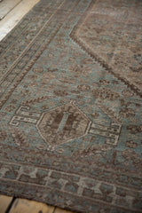 Distressed Kamseh carpet's faded dusty blue and chocolate brown geometric patterns.
