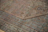 Distressed pile of vintage Kamseh carpet with faded geometric motifs and dusty blue stepped border.