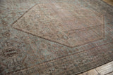 Distressed Kamseh carpet detail, geometric corner design with dusty blue and brown.