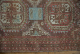 Distressed Belouch rug border with faded raspberry, chestnut brown geometric patterns, showing wear.