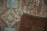 Vintage distressed Belouch rug's hand-knotted foundation, fringe, and worn geometric pile.