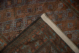 Distressed Belouch rug's folded end reveals its reverse side and sewn weighting fabric.