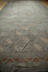 Distressed Ersari runner detail: faint floral guls, worn pile, and dark copper chevron border.