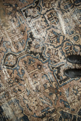 Distressed vintage Bakhtiari carpet texture showing foundation, beige, blue, and brown.