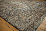 Distressed Bakhtiari carpet detail: worn pile, exposed foundation, faded beige, brown, indigo arabesques.