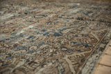 Vintage distressed Bakhtiari carpet with low pile, worn texture, and softened indigo motifs.