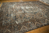 Distressed Bakhtiari carpet corner showing texture of worn pile and exposed foundation.