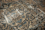 Distressed Bakhtiari rug detail: visible foundation through indigo blue and brown floral motifs.