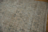 Distressed Amritsar carpet showing aged texture, visible foundation, and muted floral details.