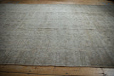 Distressed vintage Amritsar rug with faded floral patterns and exposed foundation details.
