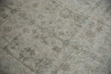 Distressed Amritsar carpet texture, with faded beige floral motifs and visible foundation.