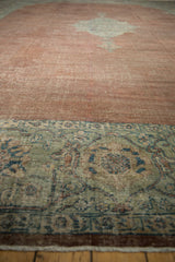 Distressed Mahal carpet with worn copper field and wide sage green floral border.