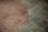Visible foundation of a distressed copper field and sage green patterned border.
